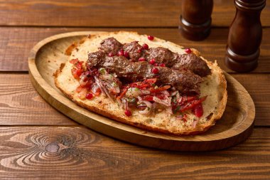 Lezzetli ızgara Lula kebabı taze domates, soğan ve bitkilerle servis edilir.