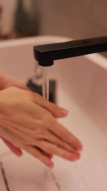 Ellerini lavabodan akan suyun altında yıkamak, temizliği ve hijyeni vurgulamak, çok önemli el yıkama pratiği konsepti.