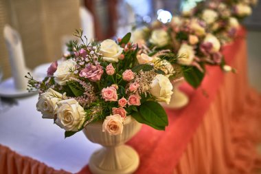 Çiçeklerin süslendiği zarif bir çiçek, yemyeşil, ve zarif pembe çiçekler düğün kutlaması için bir ziyafet masasında, romantik bir olay, çiçek düzenleme konsepti