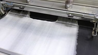 Modern tekstil fabrikasında dokumasız malzeme kullanarak endüstriyel bir ortamda kumaş üretim süreci, otomatikleştirilmiş makine kavramı