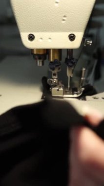 Endüstriyel dikiş makinesi, siyah kumaş dikme, tekstil üretimi için iğne, mekanik ekipmanların yakın çekimi, dikiş endüstrisi konsepti