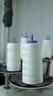 Tekstil fabrikası imalat ortamındaki büyük beyaz iplik makaraları, üretim ortamındaki ıvır zıvırların yakın görüntüsü, endüstriyel tedarik kavramı