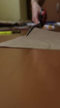 Yaratıcı proje, odaklanmış el hareketi, DIY sanat ve el sanatları konsepti için makas ile kahverengi el işi kağıdı kesen kişi