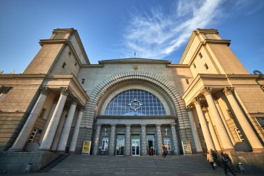 Açık mavi gökyüzü altında klasik sütunları olan büyük tren istasyonu girişi güneşli bir günde görkemli mimari tarihi yapı kavramı