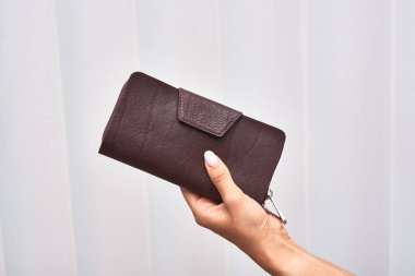 Elle tutulan şık kestane rengi cüzdan, moda bilinci olanlar için ideal bir aksesuar, cüzdan konsepti.