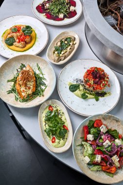 Salatalar, kremalı soslar, tartar, kızartılmış sebzeler ve sanatsal bitki temelli mutfak da dahil olmak üzere çeşitli gurme vejetaryen yemekleri tepeden tırnağa görmek..