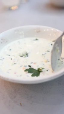 Klasik bir Rus yemeği, Okroshka, kremalı yoğurt tabanı ve taze sebzelerle yapılan soğuk bir çorbadır. Bu ferahlatıcı yemek ince doğranmış salatalık, kırmızı dolma biber ve aromatik kişniş içerir, canlı ve lezzetli bir karışım yaratır..