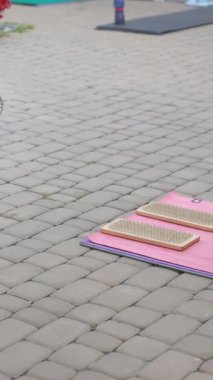 Açık havada pembe bir yoga minderine yerleştirilmiş iki tahta çivi tahtası ayak akapunktur ya da denge seansı için hazır..