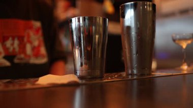 İki paslanmaz çelik kokteyl karıştırıcı. Barın üzerine konmuş. Gece hayatı ortamında içkileri karıştırmaya hazır..