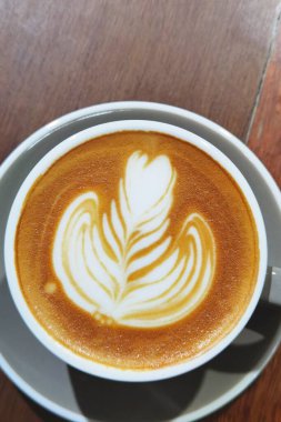  Ahşap arka planda bir fincan latte sanat kahvesi.                                                                                                                                                  