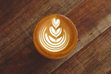  Ahşap arka planda bir fincan latte sanat kahvesi.                                                                                                                                                                                 