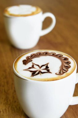  Ahşap arka planda bir fincan latte sanat kahvesi.                                                                                                                                                  