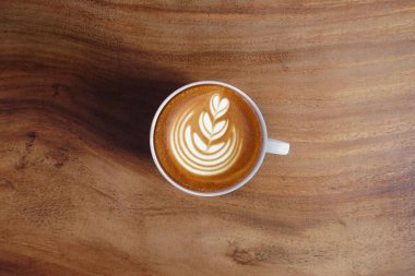  Ahşap arka planda bir fincan latte sanat kahvesi.                                                                                                                                                  