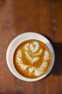  Ahşap arka planda bir fincan latte sanat kahvesi.                                                                                                                                                                                 