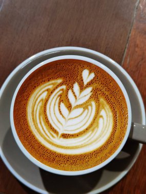  Ahşap arka planda bir fincan latte sanat kahvesi.                                                                                                                                                                                 