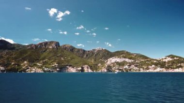 Campania 'daki Amalfi Sahili' nin yakınındaki gün batımı teknesinde seyahat ediyorum.
