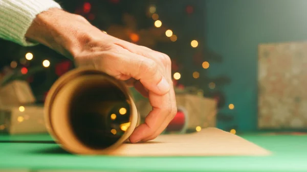 Mano Está Desenrollando Papel Regalo Navidad Sobre Mesa —  Fotos de Stock