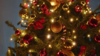 Geceleyin altın ve kırmızı topları olan Noel ağacı ve fındıkkıran.
