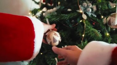 Noel Baba Noel ağacını toplarla süslüyor..