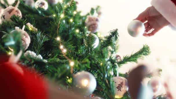 Der Weihnachtsmann Hängt Die Silberne Kugel Den Baum — Stockvideo