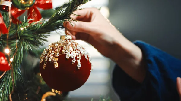 Menina Está Pendurando Uma Bola Natal Vermelho Árvore Casa — Fotografia de Stock