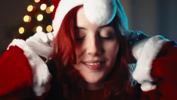 Κορίτσι Φορούν Κόκκινο Καπέλο Των Χριστουγέννων Ενάντια Στο Δέντρο — Αρχείο Βίντεο