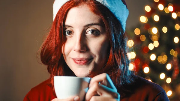 크리스마스 트리에 뜨거운 초콜릿을 마시는 — 스톡 사진
