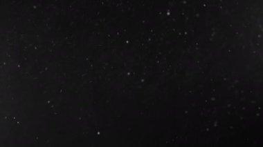 Siyah arkaplanda yüzen parçacıklar