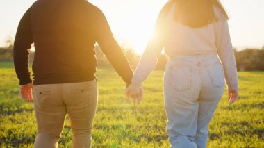 Güzel bir çift kırsalda gün batımına kadar el ele yürür..