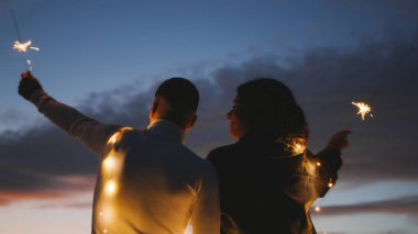 Gün batımına karşı dağlarda sevimli bir çift silueti Sevgililer Günü 'nün tadını çıkarın