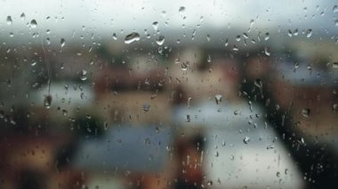 Rain crashing on the window of an house in the city during the storm.