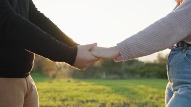 hand by hand love together outdoor in the park.