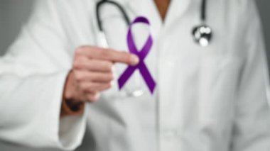 Doctor making ribbon symbol for world awareness cancer day.