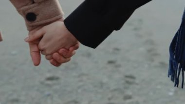 Kumsalda el ele tutuşan çift..