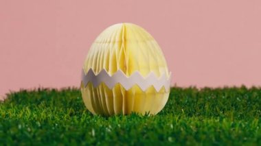 Pembe arka planı olan sarı bir Paskalya yumurtası..