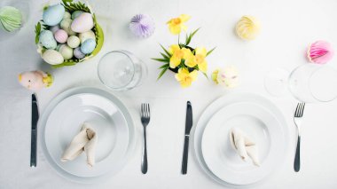 Renkli yumurta ve çiçekli Paskalya masası..