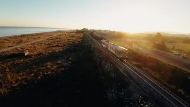 Seguimiento Tren Cerca Del Océano Atardecer Con Fpv Drone — Vídeos de Stock