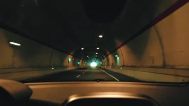Araba aydınlık bir yol tünelinden geçiyor..