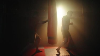 Spor salonunda boks yaparken kum torbasında ve ringde.