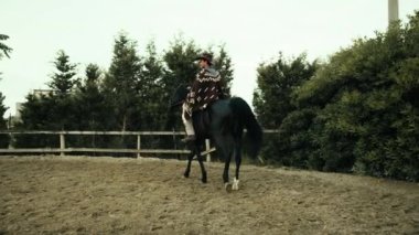 Çiftlikteki ata kovboy elbiseli bir adam biner..