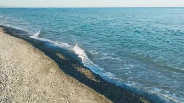 穏やかな波が吹く夏の海の近くの空のビーチ — ストック動画