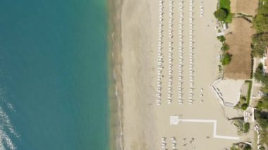 Yaz sabahı için şemsiyeli kumsal, dikey hava..