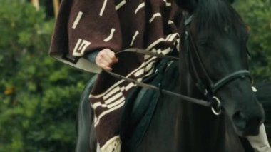 Çiftlikteki ata kovboy elbiseli bir adam biner..