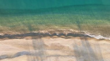 Yaz mevsiminde okyanus kıyısında sakin su dalgalarıyla bomboş bir sahil.