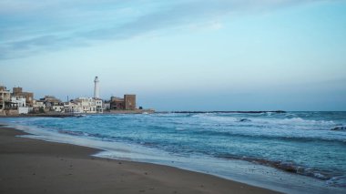 Sicilya 'nın Punta Secca şehrinde gün ışığında beyaz kule deniz feneri..