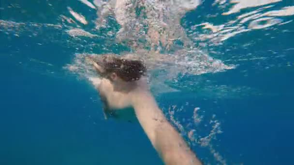 日没の海で泳ぐ少年 — ストック動画