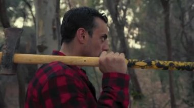 Akşamları elinde satırla ormanda yürüyen korkmuş bir adam.