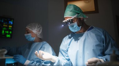 Diş hekimi cerrahi aletlerle diş çıkarıyor..