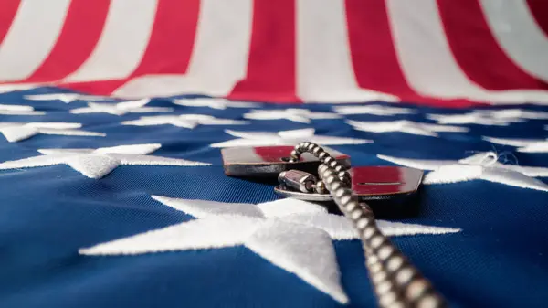 Military dog tag crawling on a USA flag for Veterans Day.