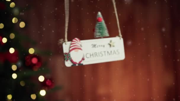 バックグラウンドの木で落ちるメリークリスマスパッチ — ストック動画